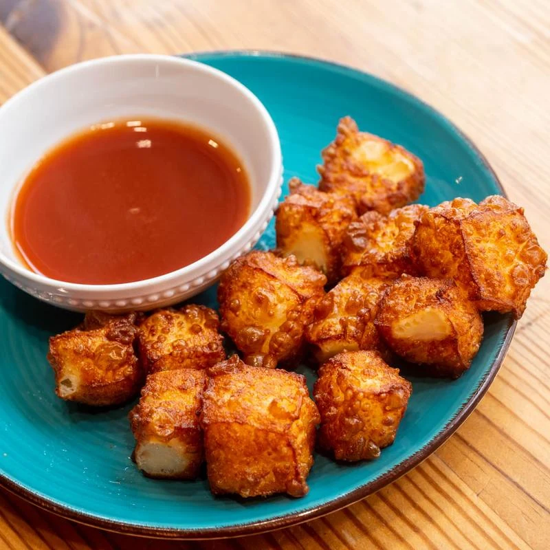 Kokí queso frito with dipping sauce on a turquoise plate